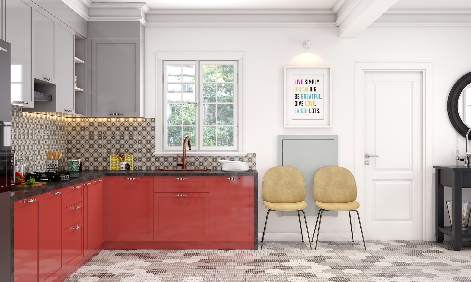 Modern modular kitchen with red cabinets and foldable breakfast table has two yellow chairs