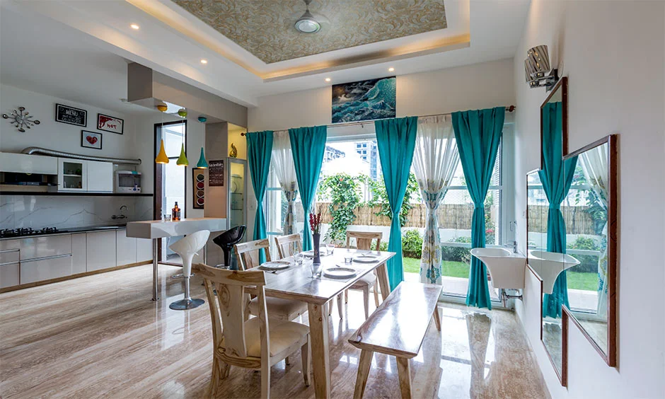 A bright 2BHK dining area combines seating, storage and a contemporary interior finish.