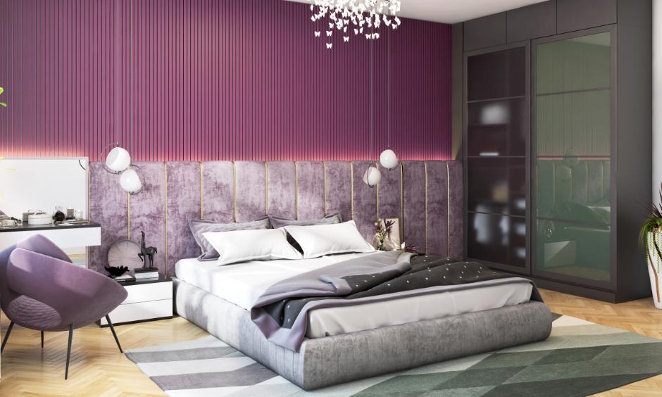 Bedroom with muted lavender wall and velvet headboard in a calm, elegant setting.