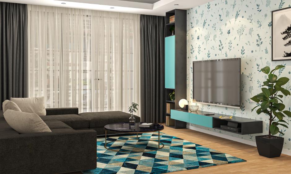 Living room with soothing blue wall, patterned rug and soft furnishings.
