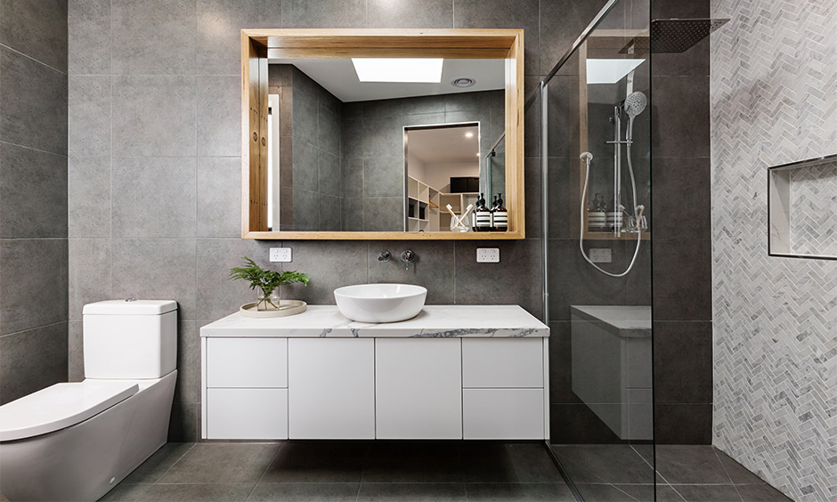Small bathroom renovation uses a large mirror, layered lighting, and floating vanity to create spaciousness.