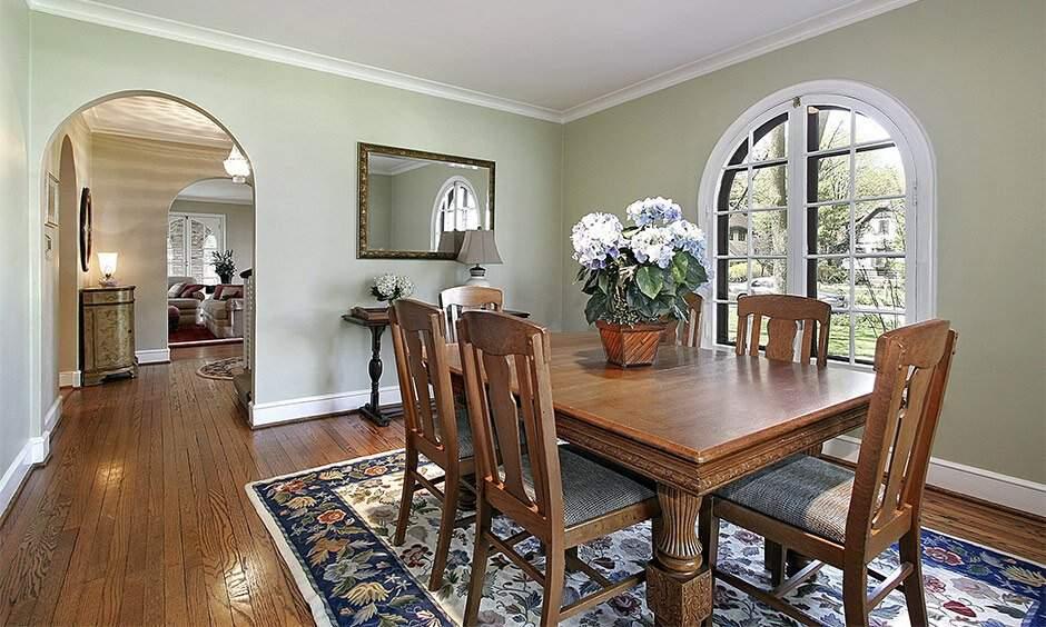 Elegant Italian-style interior living room with velvet sofa, marble floor, arched windows, warm tones.
