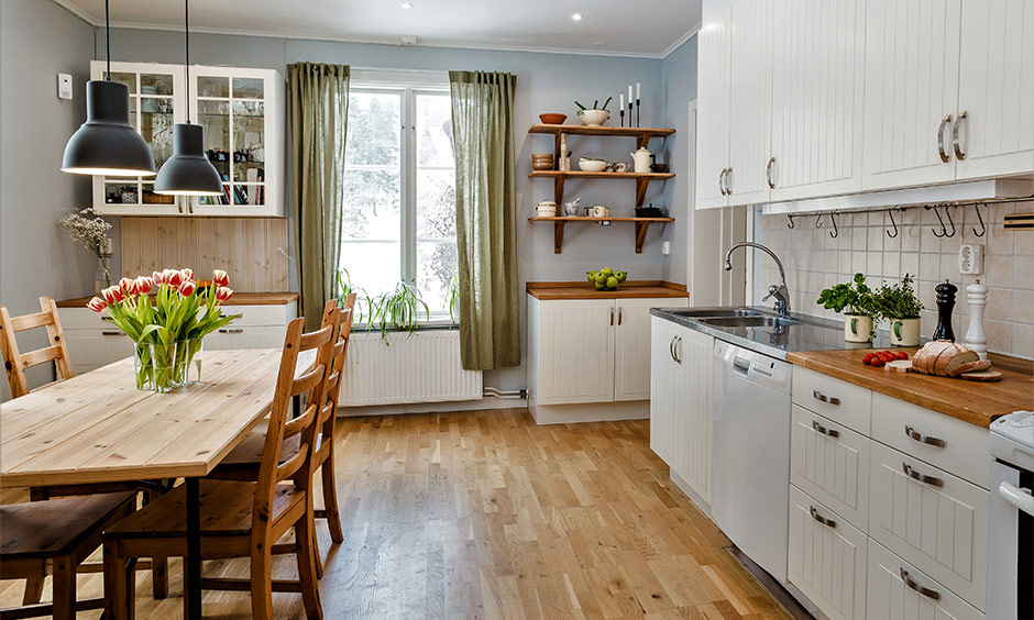 Olive green kitchen window curtain enhancing the powder-blue decor and warm wooden interiors.