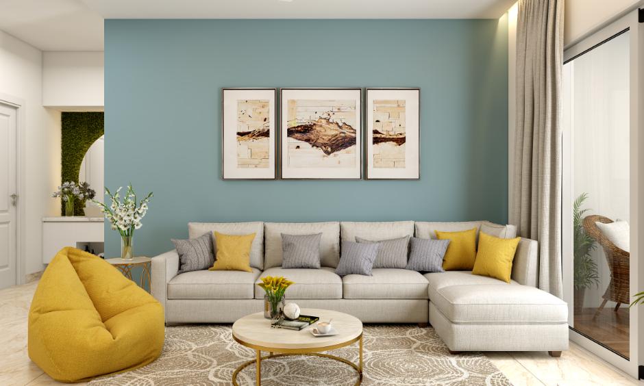 Living room with teal acrylic wall colour and wall art frames, styled with a beige sectional sofa and yellow accents.