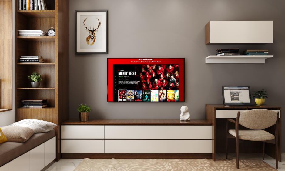 Contemporary living room with grey acrylic wall colour behind a TV and study unit, styled with minimal decor.