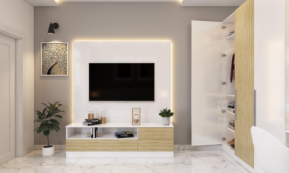 Living room with neutral acrylic wall colour behind a TV unit, styled with minimal décor and warm lighting