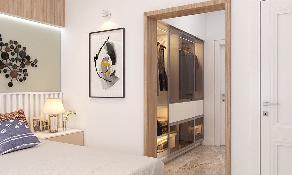 Bedroom with a small luxury walk-in closet featuring sliding glass doors and organised storage