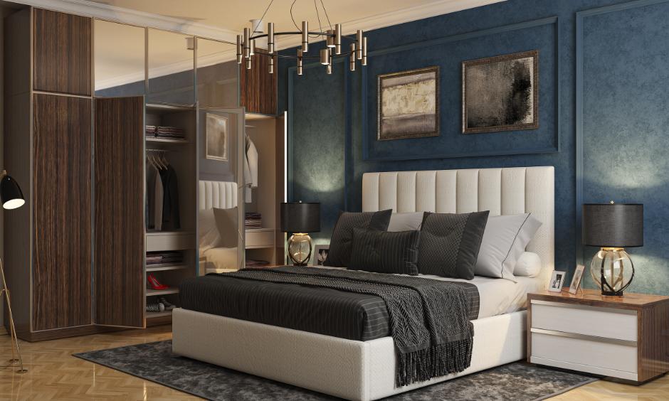 Upholstered hydraulic bed design in a stylish modern bedroom with a wooden wardrobe and blue wall decor.