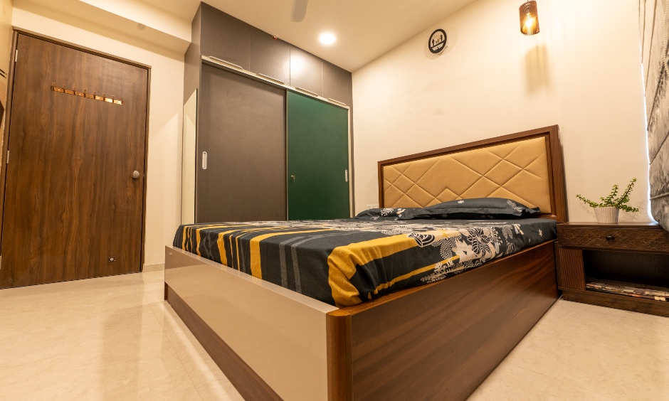 Minimal bedroom with sliding wardrobes and an upholstered headboard at Majestique Towers Pune