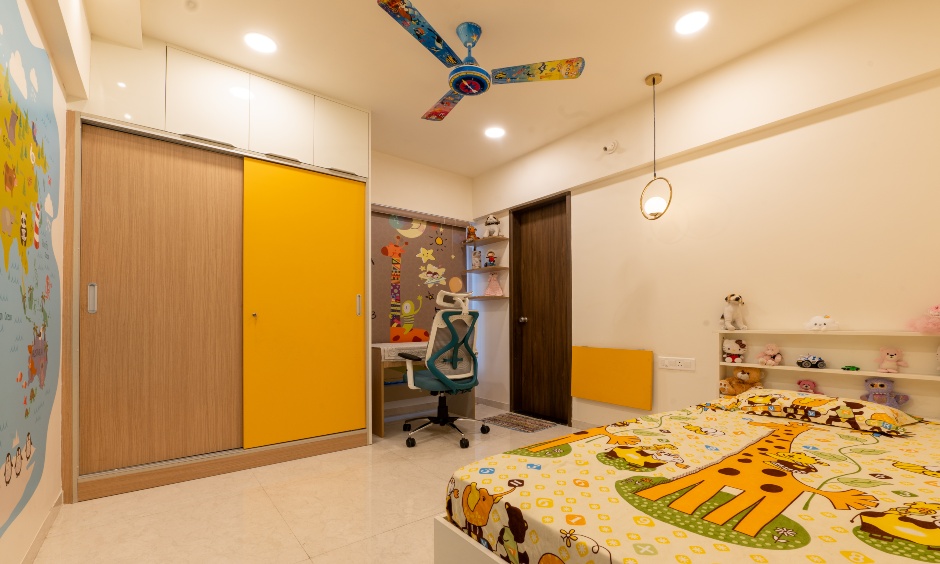 Bright kids room with yellow wardrobe and small study nook at Majestique Towers Pune