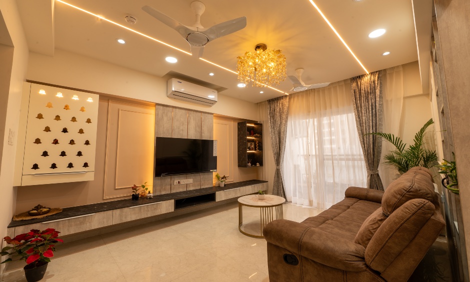 Living room with floating TV panel, warm lighting and modern mandir unit at Majestique Towers Pune