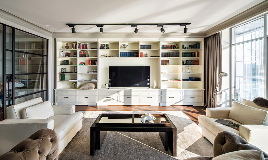 Floor-to-ceiling TV unit with side storage, designed to showcase decorative items and media accessories.