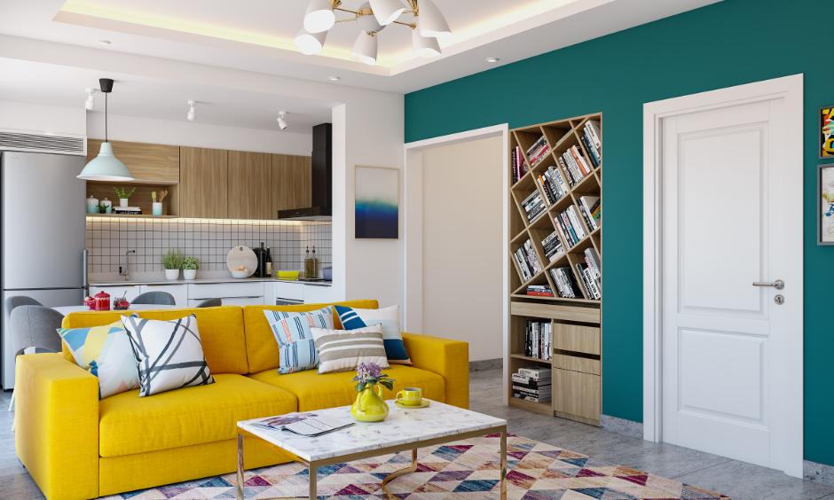 Modern Hyderabad living room cost featuring a yellow sofa and an open kitchen showcasing budget-friendly interiors