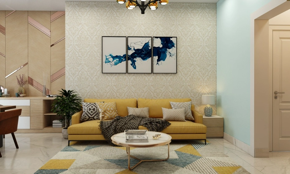 Hall with mustard seating, cream walls, a pale blue accent and a round central coffee table
