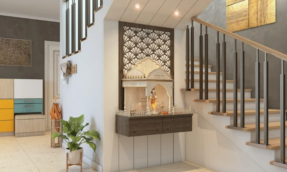 A carved jaali backdrop and floating wooden base suit a compact wooden mandir in a staircase nook.
