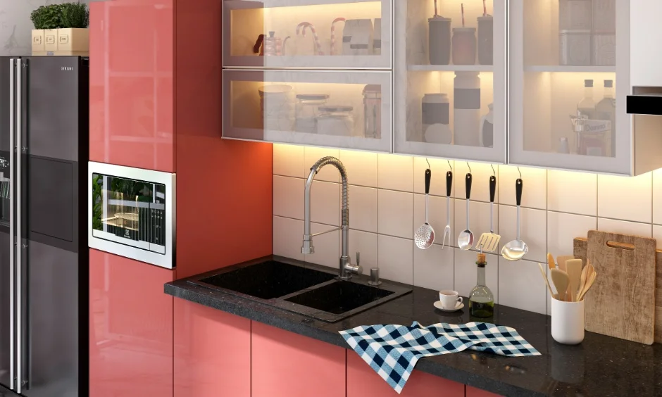 Modular kitchen with peach cabinets and black countertop in a 1 BHK interior Home.