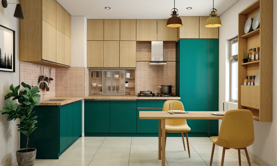 Modern L-shaped modular kitchen cost in Hyderabad featuring green base units, wood finish overhead cabinets, and a small dining table with yellow chairs.