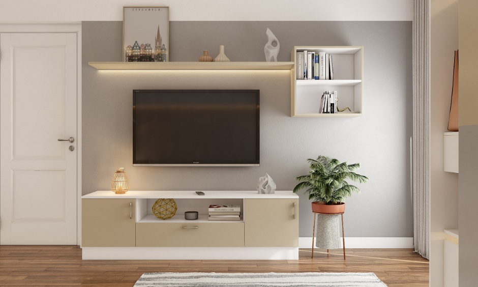 Modern 2BHK living room interior cost in Hyderabad featuring a wall with a floating TV unit, an overhead shelf, a compact book cabinet, and soft cove lighting