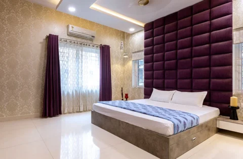 An upholstered headboard rises above the bed with enough height to clear stacked pillows.