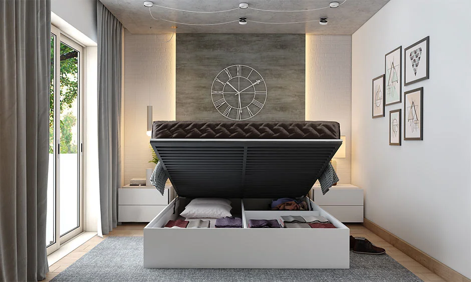 A textured grey ceiling with track lighting sits above a storage bed lifted open