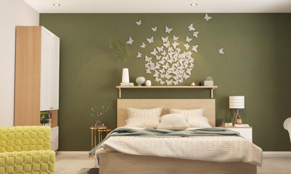 Sage green accent wall in bedroom with white furniture and decor creating a fresh and natural focal point