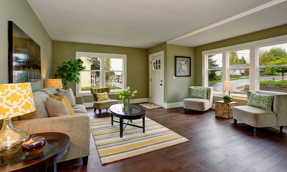 Warm white and sage green living room with natural light, cosy seating and a bright, welcoming feel