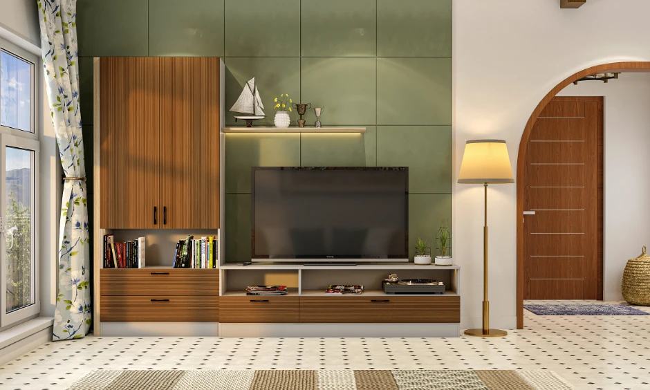 Earthy living room design with olive green panelled walls, wood cabinets, and an arched doorway in an Indian home.