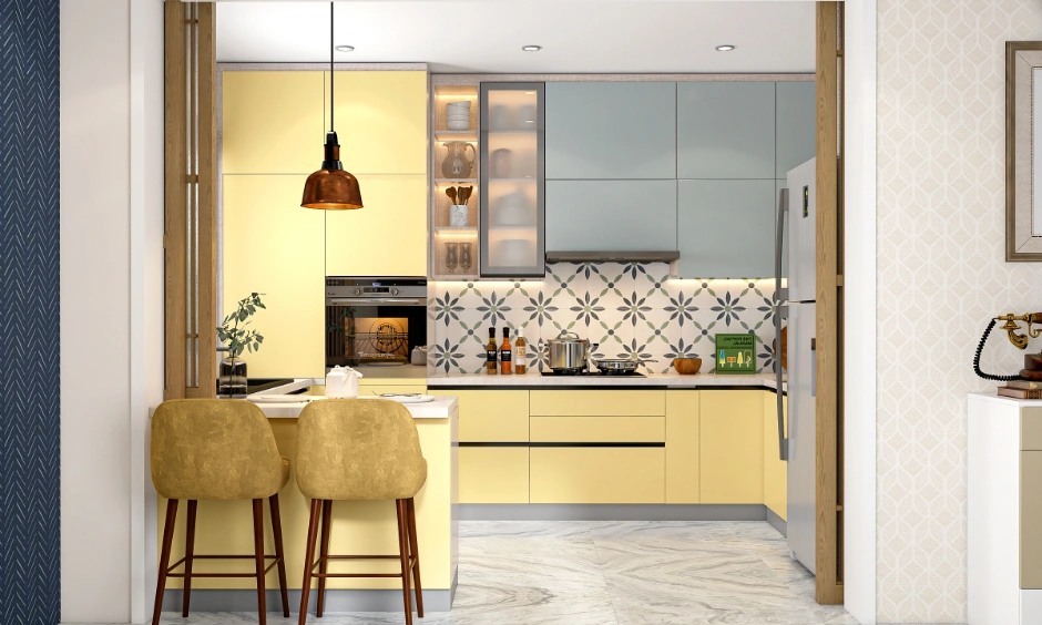 Modern U-shaped dual tone modular kitchen with yellow cabinets, a breakfast counter, and patterned backsplash for 2BHK.