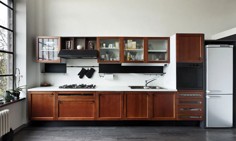 Kerala style kitchen with wooden cabinets, granite counters and ample ventilation.