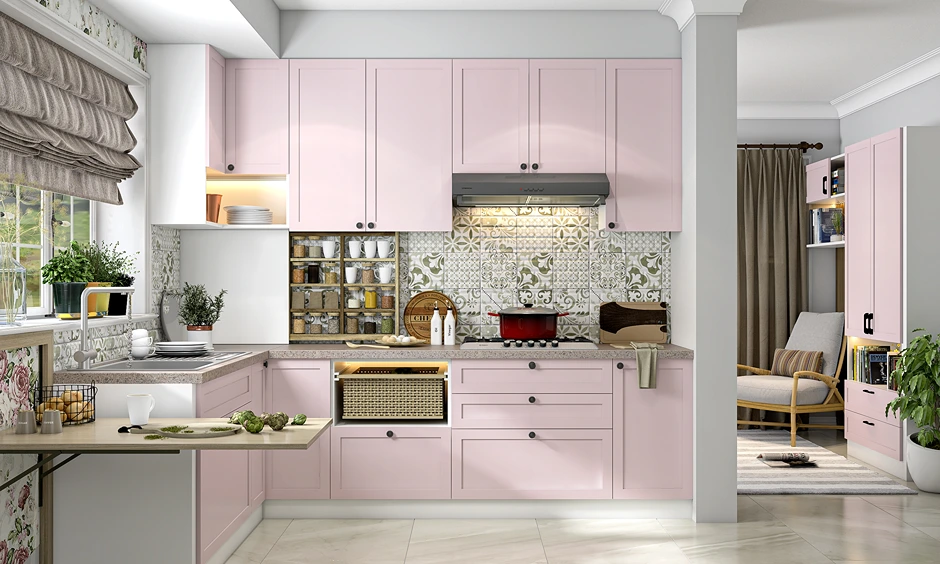 Soft matte pink L-shaped kitchen with floral tile backsplash and wooden breakfast ledge.