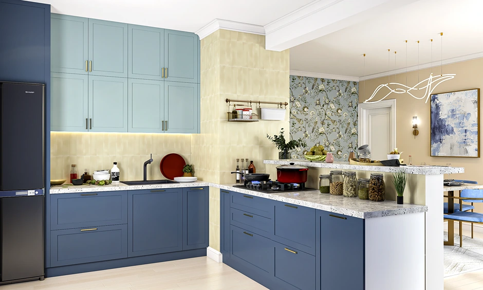 Modern L-shaped navy and pastel blue kitchen with brass handles and terrazzo quartz countertop.