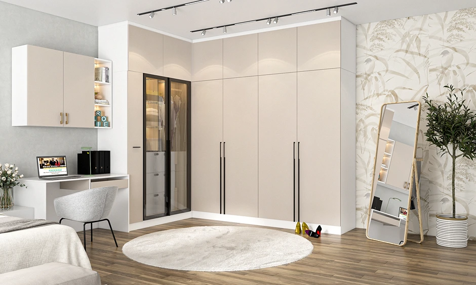 Contemporary bedroom design featuring an L-shaped wardrobe in beige, integrated study unit, and a full-length mirror.
