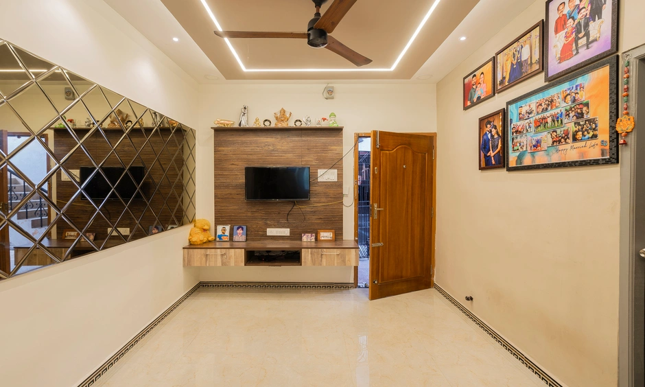 Rustic veneer TV unit with wall panelling in modern 2BHK living room, Chennai.