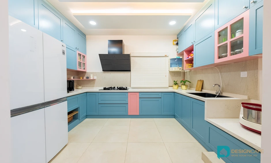Dual-toned pastel kitchen with handleless cabinets and smart storage solutions for an urban Bengaluru apartment.