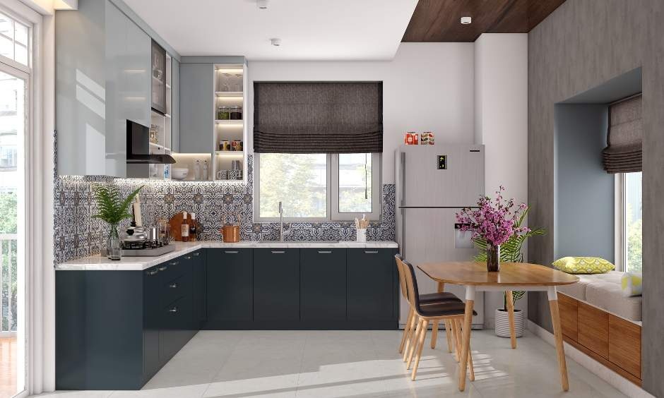 Modern kitchen and dining space in Kolkata with blue cabinets, patterned backsplash, window seating, and a compact dining table with natural light