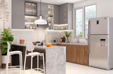 Modern off-white modular kitchen designed by a kitchen interior designer in Kolkata, featuring wooden cabinets, a breakfast counter, pendant lighting, and ample natural light from a large window.