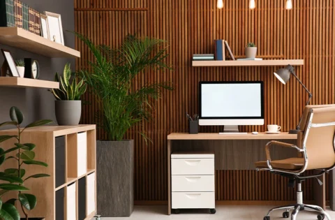 Modern home office workspace with clean slatted wood cladding unifying the wall plane and integrated storage zone.