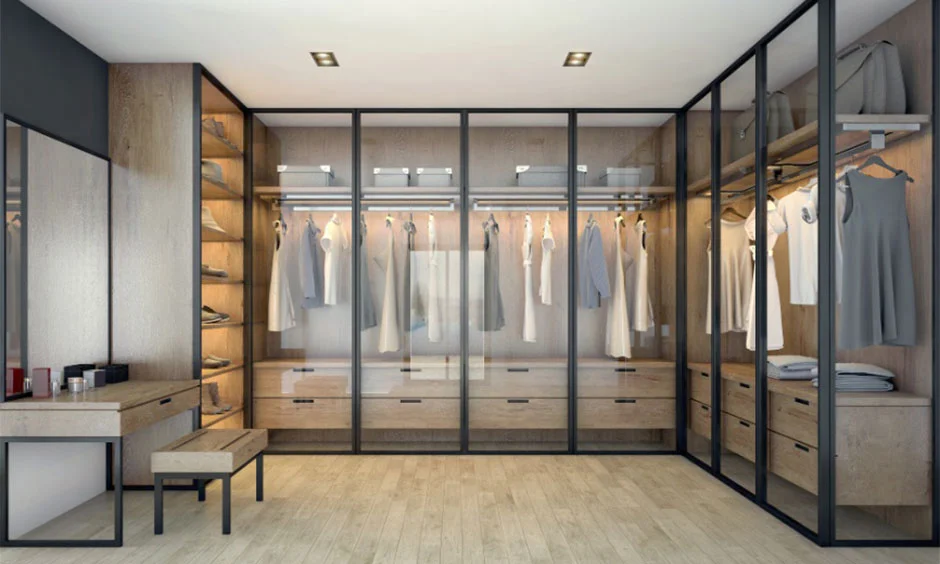 Oak walk-in wardrobe with black-framed glass doors and a minimalist vanity creates a premium dressing space.