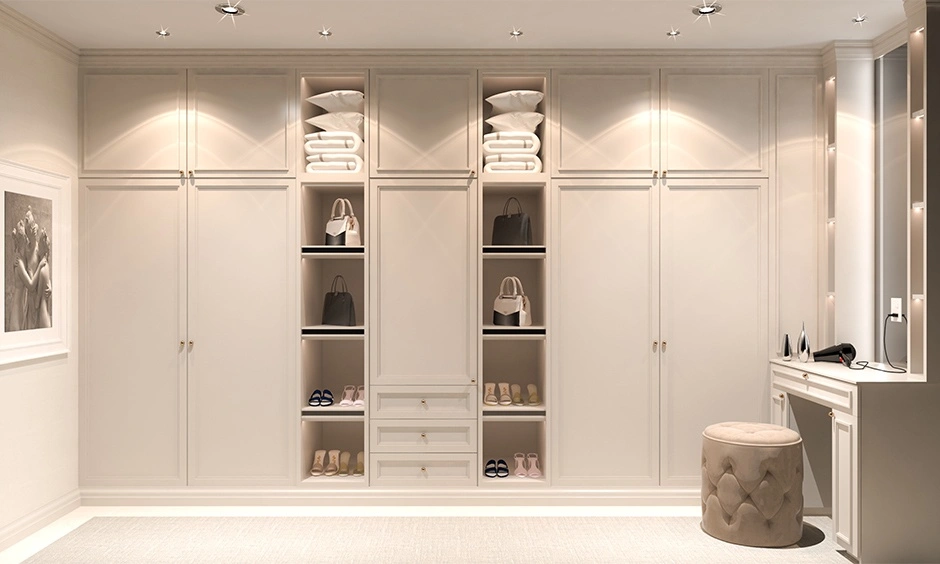 Floor-to-ceiling ivory walk-in wardrobe with open display shelving maximises storage and organisation.