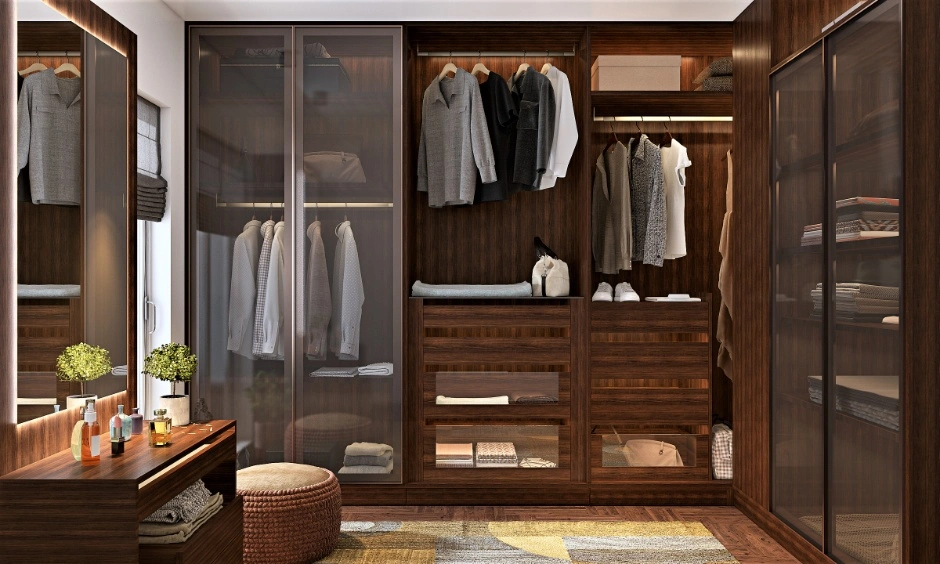 Dark walnut walk-in wardrobe with glass sliding doors and a backlit dressing counter enhances functionality.