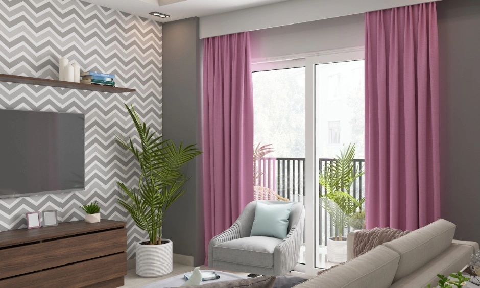Living room interiors in NCR with patterned flooring, pink curtains, TV unit, indoor plants, sofa seating and soft furnishings.