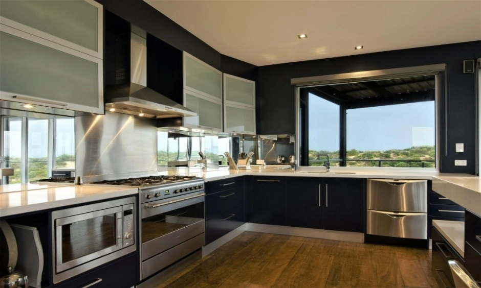 Kitchen with dark finishes and a large window showing how materials can enhance ceiling light.
