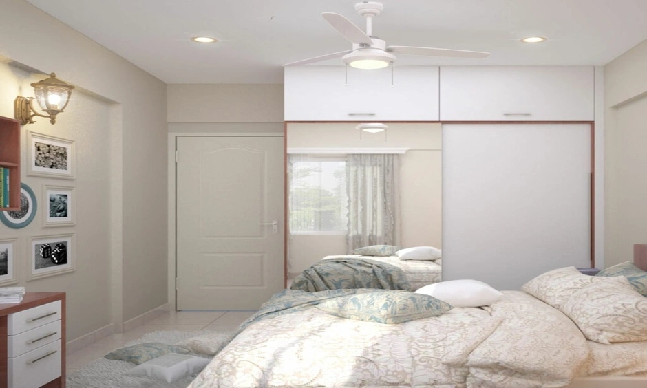 Sliding wardrobe doors with full-length mirrors and loft storage maximise space in a small bedroom.