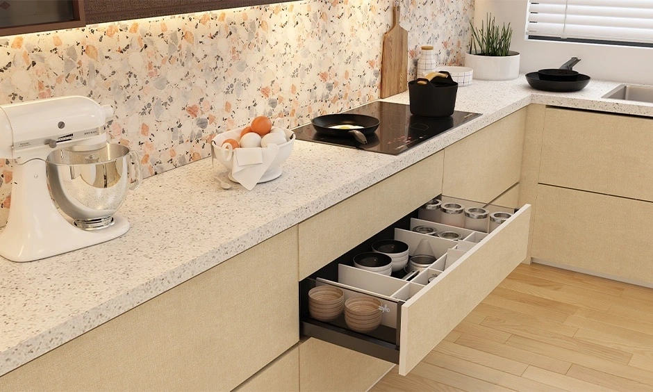 A sustainable kitchen features a granite countertop and brushed steel drawers.