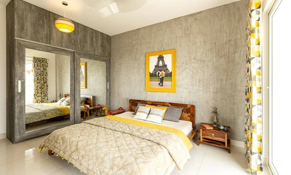 Wall-mounted shelves and a compact desk create practical storage in this bedroom.