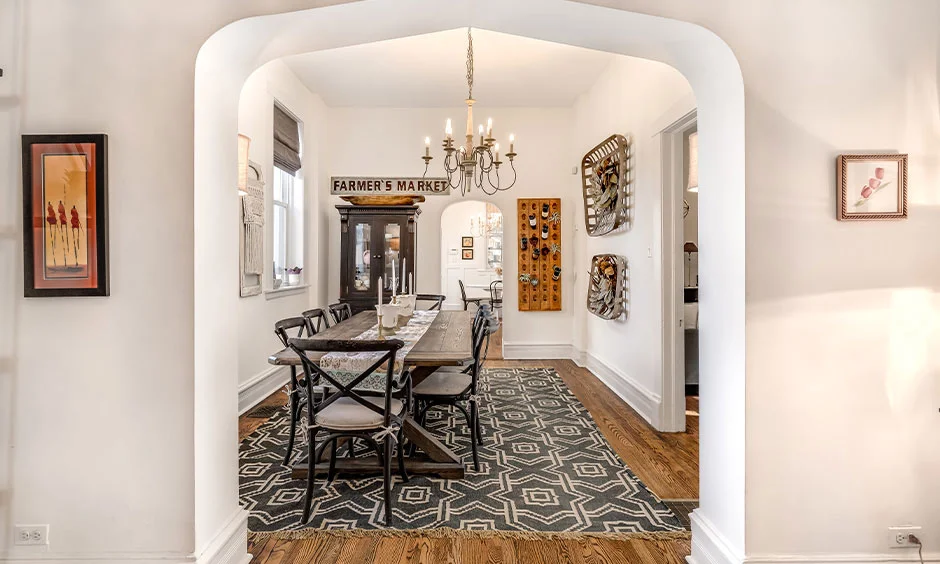 A farmhouse-style dining room features a reclaimed wooden table