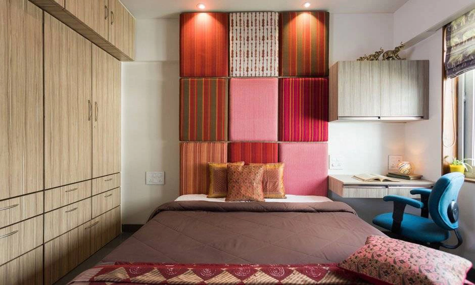 A bespoke headboard features traditional Indian-inspired detailing behind the bed.