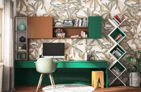 A deep green study table with floating shelves integrates storage while saving space.