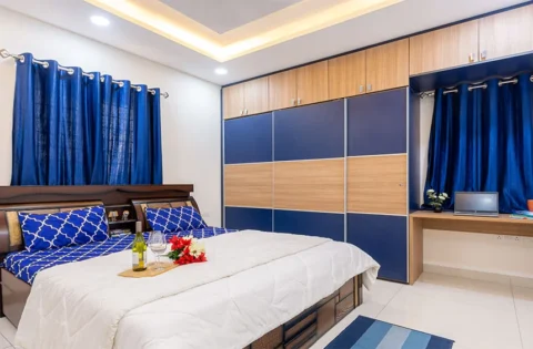 Master bedroom with a floor-to-ceiling blue and light wood sliding wardrobe.