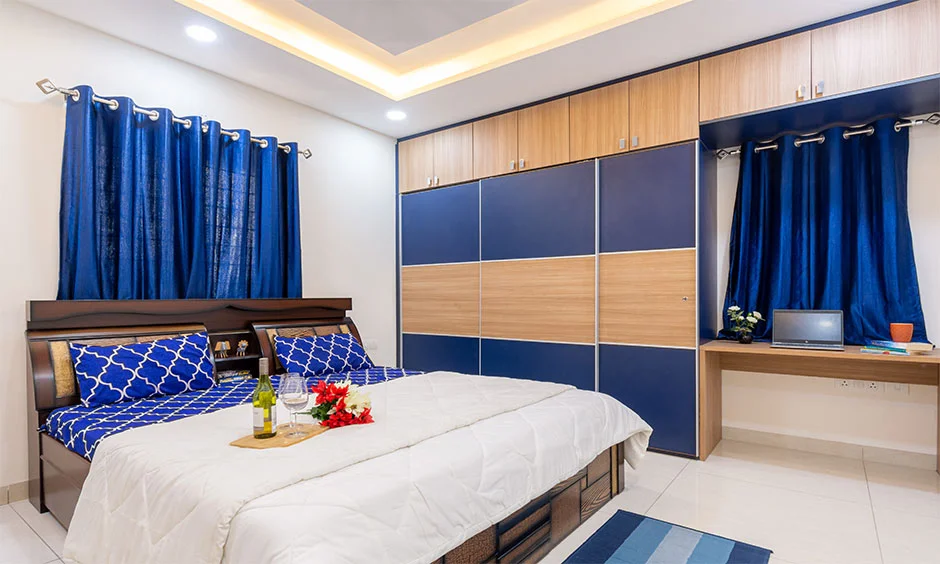 Master bedroom with a floor-to-ceiling blue and light wood sliding wardrobe.